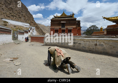 Buddismo tibetano, prostrazione, pellegrino tibetano, un credente buddista sul kora sentiero dei pellegrini, Labrang Monastero, Xiahe, Gansu Foto Stock