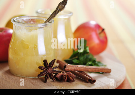 La marmellata di mele in vasi con cannella e menta sul bordo di taglio Foto Stock