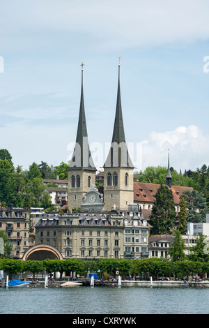 Vista della Hofkirche San Leodegar chiesa con i campanili e il quartiere storico di Lucerna si vede attraverso il lago di Lucerna Foto Stock