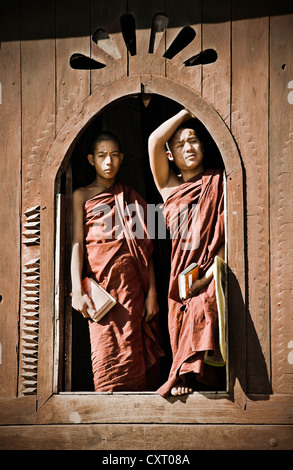 Due monaci in piedi in una finestra di Shwe Yan Bye monastero in Birmania, Myanmar, Asia sud-orientale, Asia Foto Stock