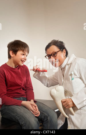 Ragazzo dal dentista, cure dentarie istruzioni con un modello di denti Foto Stock