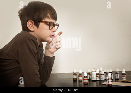 Ragazzo con bottiglie di globuli Foto Stock