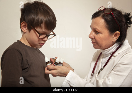 Ragazzo essendo dato da globuli di un homoeopath Foto Stock