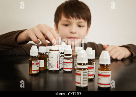 Ragazzo con bottiglie di globuli Foto Stock