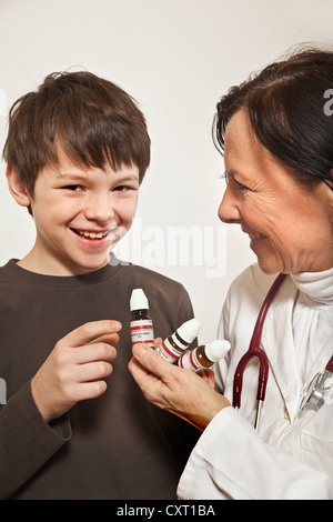 Ragazzo essendo dato da globuli di un homoeopath Foto Stock