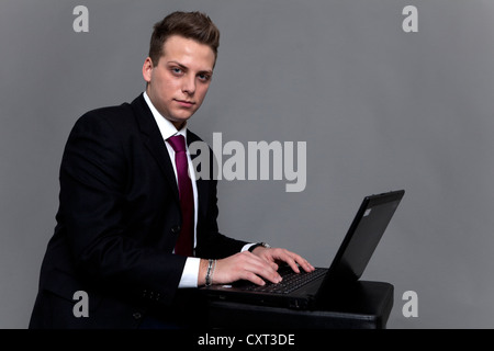 Giovane uomo nel business suit e legare con un notebook Foto Stock