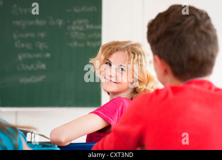 Scolaro girando intorno ai suoi compagni di classe durante la classe Foto Stock