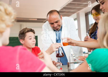 Insegnante che mostra un esperimento durante una chimica classe Foto Stock