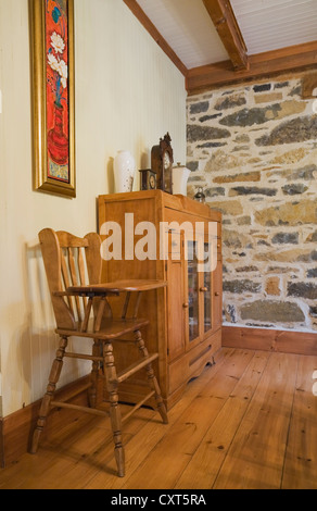 Sedia alta e piccola credenza nella sala da pranzo di un vecchio Canadiana in stile cottage fieldstone residenziale home, circa 1832, Foto Stock