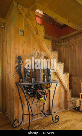 Portabottiglie di vino nella parte anteriore di una vecchia scala di legno in un vecchio cottage Canadiana residenziale in stile casa di registro, circa 1840, Quebec, Foto Stock