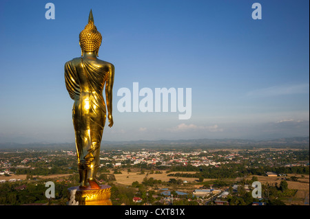 Golden statua del Buddha, a piedi, in vista della città di Nan, Wat Phra That Khao Noi, Nan, Thailandia del Nord della Thailandia, Asia Foto Stock