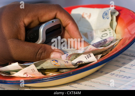 Mano e banconote, Rand o ZAR, la moneta del Sud Africa, offerte sacrificali, Sangoma o Witchdoctor Festival Foto Stock