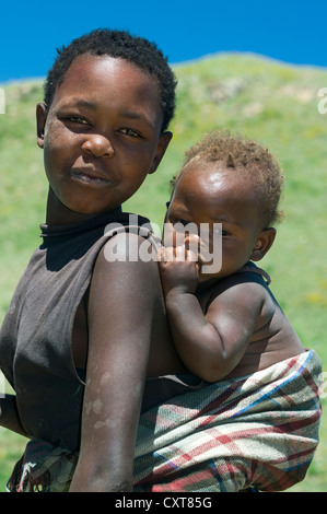 La donna che porta il bambino sulla schiena, altopiani, Regno di Lesotho, Africa Foto Stock