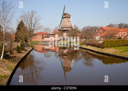 Mulino a vento su un canale in Hinte, Frisia orientale, Bassa Sassonia Foto Stock