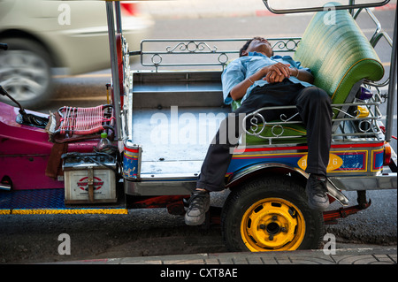 Tuk-Tuk driver dormire nel suo veicolo, Bangkok, Thailandia, Asia Foto Stock