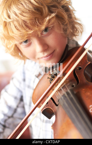 Ragazzo la pratica di violino a casa Foto Stock