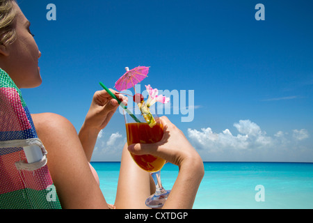 Donna con drink tropicale sulla spiaggia Foto Stock