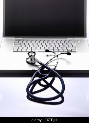 In prossimità di uno stetoscopio sul computer portatile Foto Stock
