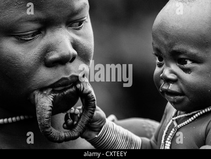 Suri Tribe donna con labbro allargata e il suo bambino in una cerimonia organizzata dal governo, Kibish, Valle dell'Omo, Etiopia Foto Stock