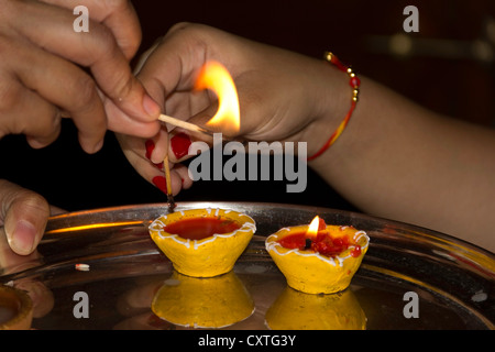 Cercando la luce di una lampada ad olio che si spenga. Questo è parte delle celebrazioni Diwali dove lampade ad olio sono illuminati come parte della preghiera. Foto Stock