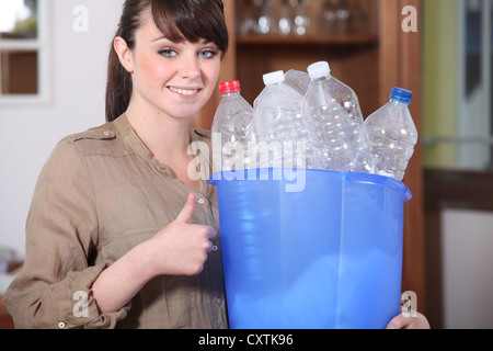 Giovane donna il riciclaggio di bottiglie in plastica Foto Stock