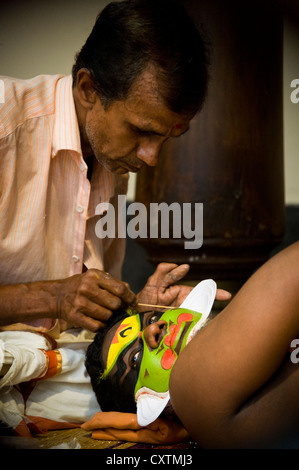 Chiudere verticale su ritratto di un Kathakali performance di artista essendo costituito prima dell'esecuzione. Foto Stock