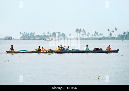 Vista orizzontale dei lavoratori tornando a casa alla fine della giornata in canoe tradizionali nelle lagune del Kerala. Foto Stock
