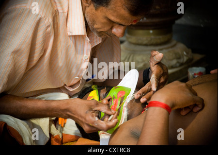 Chiudere orizzontale su ritratto di un Kathakali performance di artista essendo costituito prima dell'esecuzione. Foto Stock