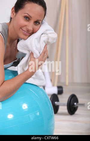 Donna in palestra tergi il suo volto Foto Stock