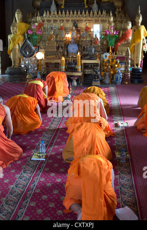 I monaci buddisti si impegnano nella preghiera al Wat Mahathat a Luang Prabang, Laos Foto Stock