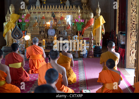 I monaci buddisti si impegnano nella preghiera al Wat Mahathat a Luang Prabang, Laos Foto Stock