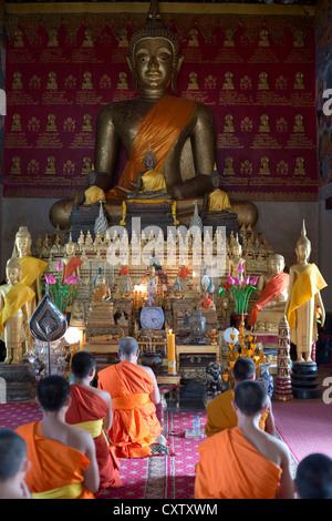 I monaci buddisti si impegnano nella preghiera al Wat Mahathat a Luang Prabang, Laos Foto Stock