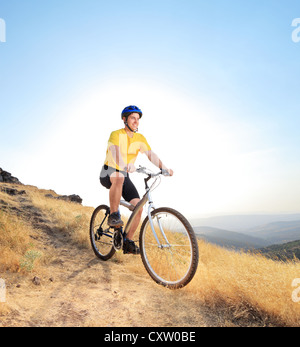 Un biker in sella ad una mountain bike su una strada sporca, Macedonia Foto Stock