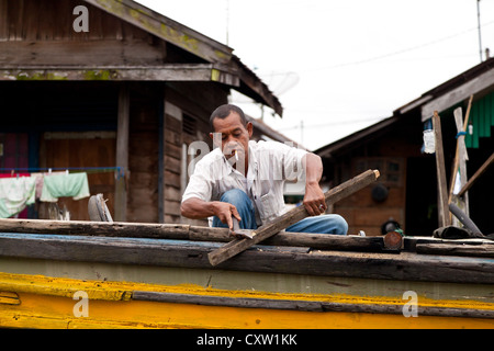 Fumatori Uomo su una barca fluviale in Banjarmasin, Indonesia Foto Stock