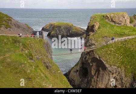 Ballintoy Co Antrim Irlanda del Nord i visitatori attraversando il famoso Carrick-a-Rede ponte di corde per l'isola Foto Stock