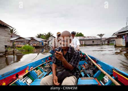 Un uomo su una barca fluviale in Banjarmasin, Indonesia Foto Stock