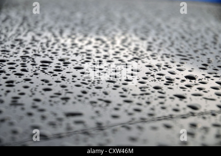 Lowestoft, Suffolk, Inghilterra: gocce di pioggia formano un disegno astratto sul tetto di un'automobile Foto Stock