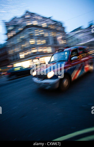 Taxi a Londra in movimento - Motion Blur colpo di London Black Cab in Unione Jack decor. Foto Stock