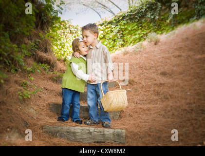 Adorable del fratello e sorella di bambini con cestello abbracciando all'esterno. Foto Stock