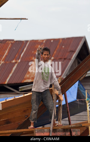 Costruttore di barca su un cantiere navale tradizionale per Imbarcazioni da fiume in Banjarmasin, Kalimantan, Indonesia Foto Stock