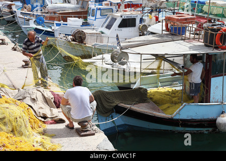 I pescatori la riparazione di reti da pesca Heraklion Creta Grecia Foto Stock