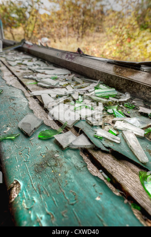 Sostituzione necessaria per windows in frantumi vetro su cills e il vecchio involucro di acciaio peeling vernice da legno con la maniglia in posizione socchiusa Foto Stock