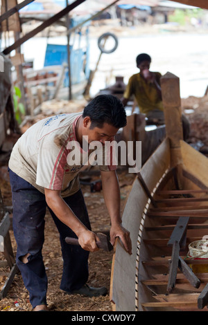 Costruttore di barca su un cantiere navale tradizionale per Imbarcazioni da fiume in Banjarmasin, Kalimantan, Indonesia Foto Stock