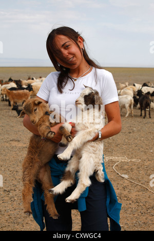 Ritratto di ragazza caucasica tenendo un agnello nelle sue braccia, Mongolia Foto Stock