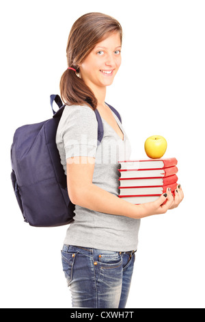 Un sorridente schoolgirl contenere libri e mela verde isolato su sfondo bianco Foto Stock