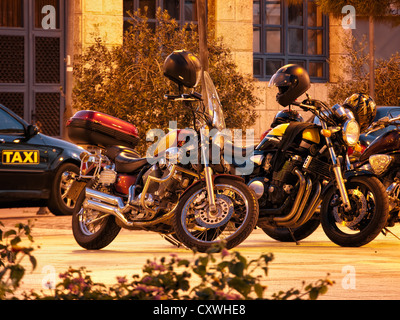 Vista su diverse moto parcheggiate nella piazza della città. Foto Stock