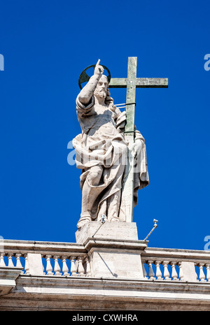 Statua di Gesù Cristo che porta la croce sulla cima della Basilica di San Pietro e la Città del Vaticano, Roma, Italia. Foto Stock