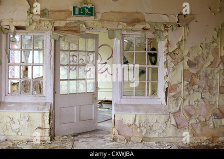 Vernice scrostata fuori le mura di un antico edificio vuoto, Barrow Gurney Ospedale Psichiatrico vicino a Bristol, 9 Aprile 2012 Foto Stock