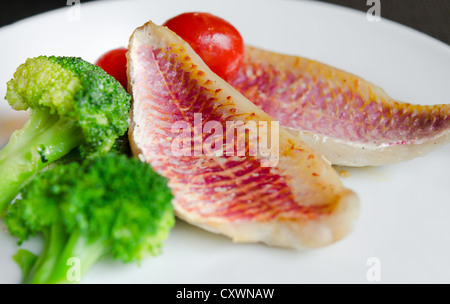 Piatto di pesce con verdure fresche sul piatto bianco Foto Stock