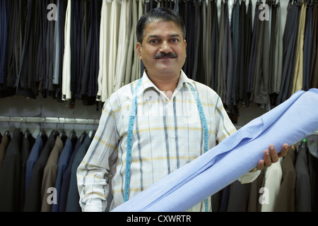 Sarto holding tessuto in negozio Foto Stock